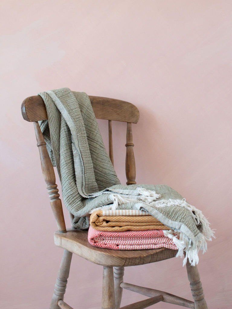 Colourful hammam towels folded on a wooden chair