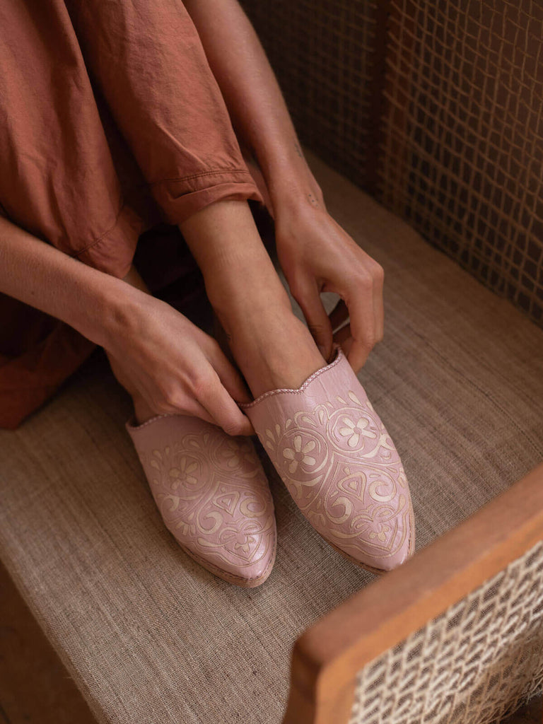 Model putting on a pair of decorative babouche slippers in vintage pink