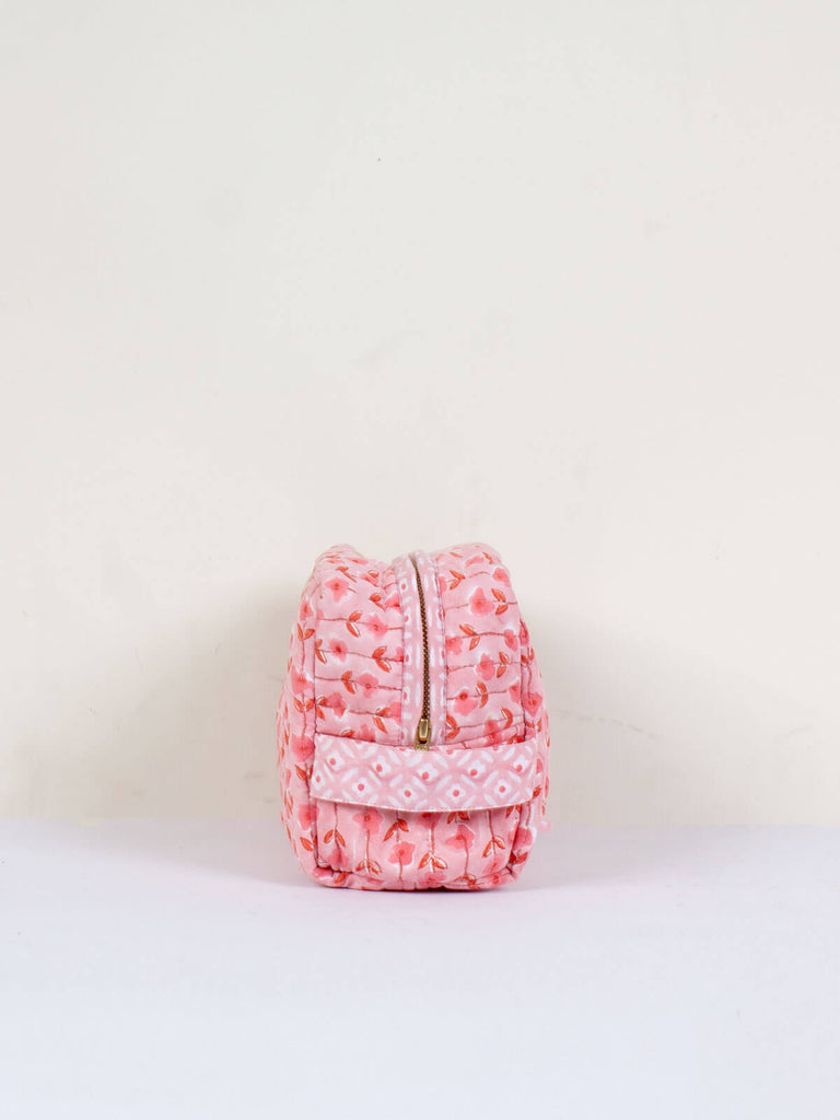 The practical carry handle on the side of a vintage pink quilted Garland washbag