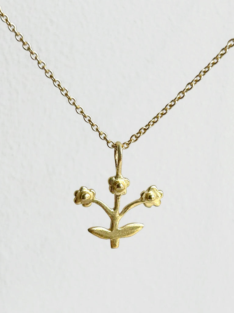 Wholesale minimalist gold necklace featuring a posie flower pendant on fine gold chain