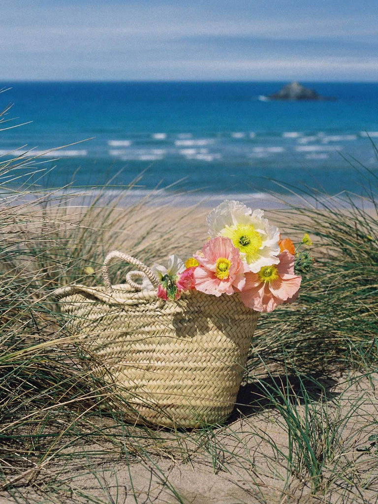 Market Basket filled with flowers on a beach overlooking the sea