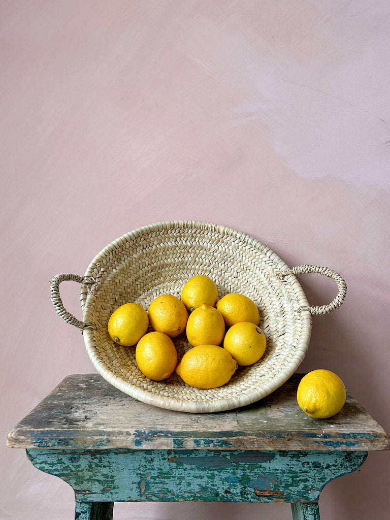 Small Moroccan woven plate or platter holding lemons