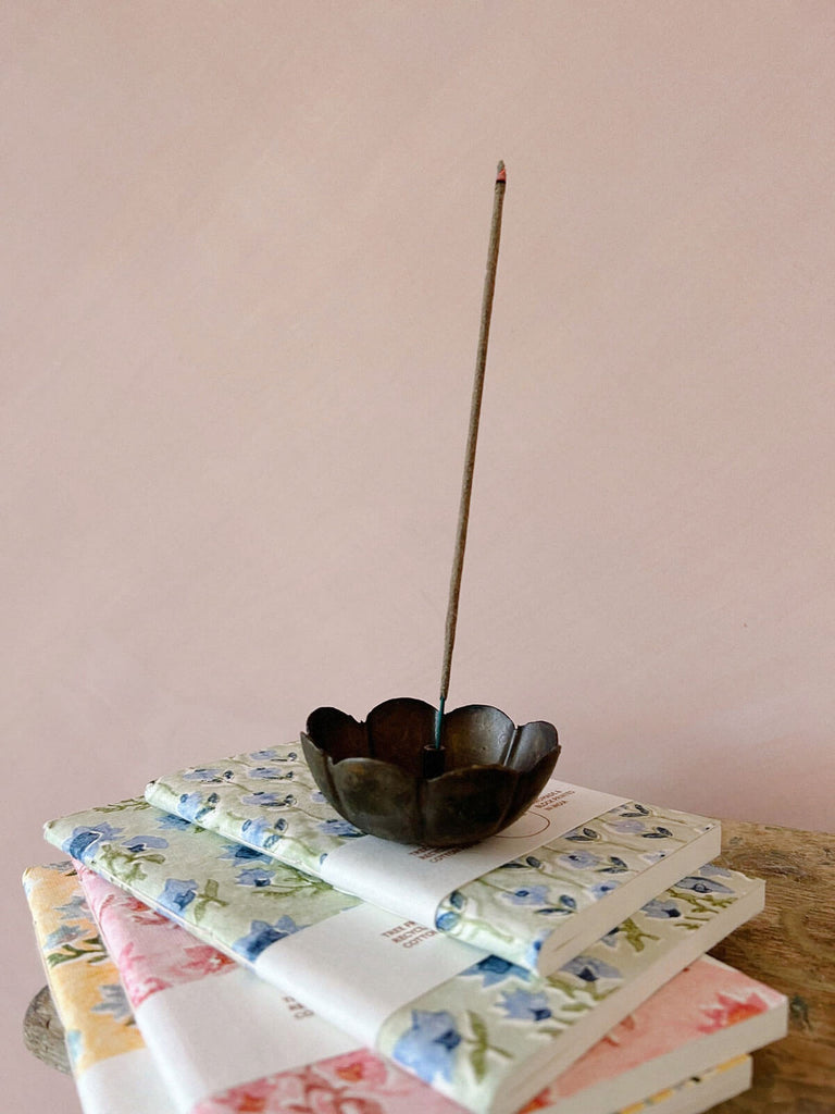 Poppy incense holder on a stack of floral notebooks