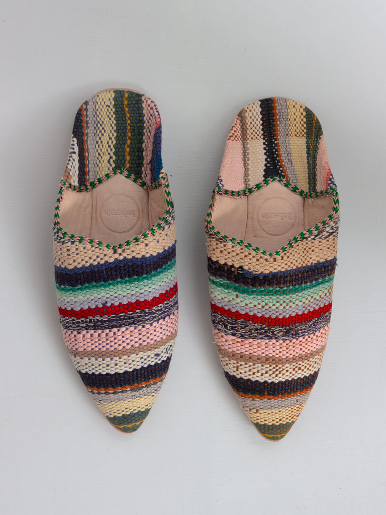 A pair of limited edition Moroccan boujad fabric and leather pointed babouche slippers with a pastel stripe pattern. 