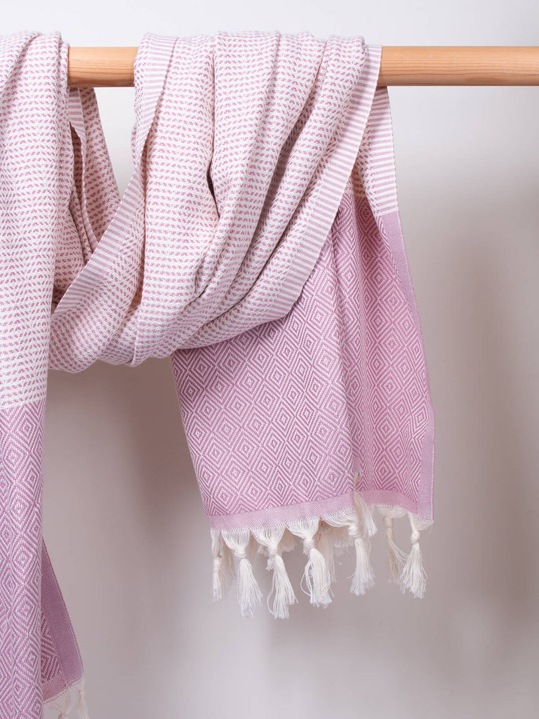 Nordic Dot Hammam Towel in vintage pink diamond pattern by Bohemia Design hanging on a wooden rod