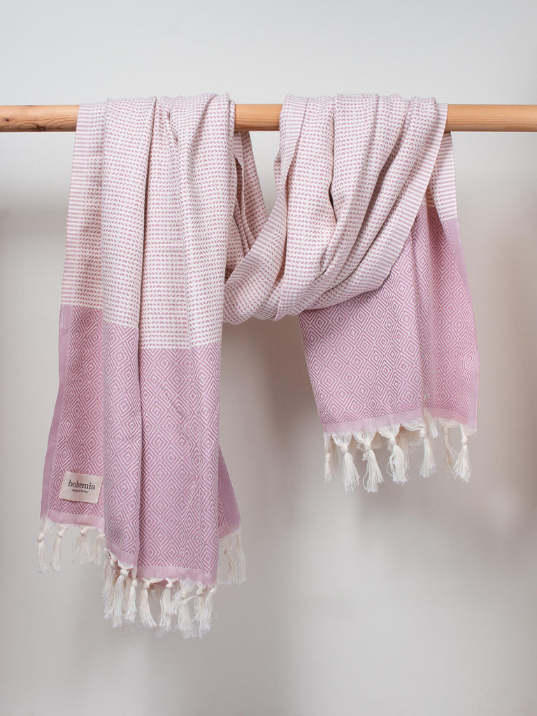 Nordic Dot Hammam Towel in vintage pink diamond pattern by Bohemia Design hanging on a wooden rod