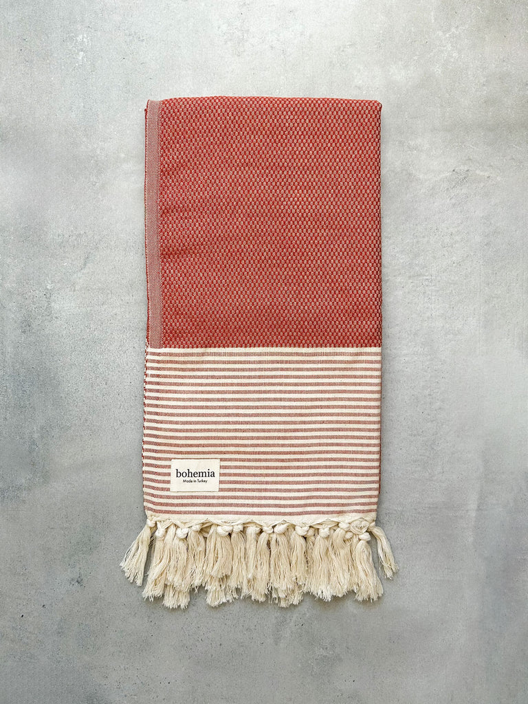 Tactile cotton towel in a textured weave with striped borders in terracotta by Bohemia Design
