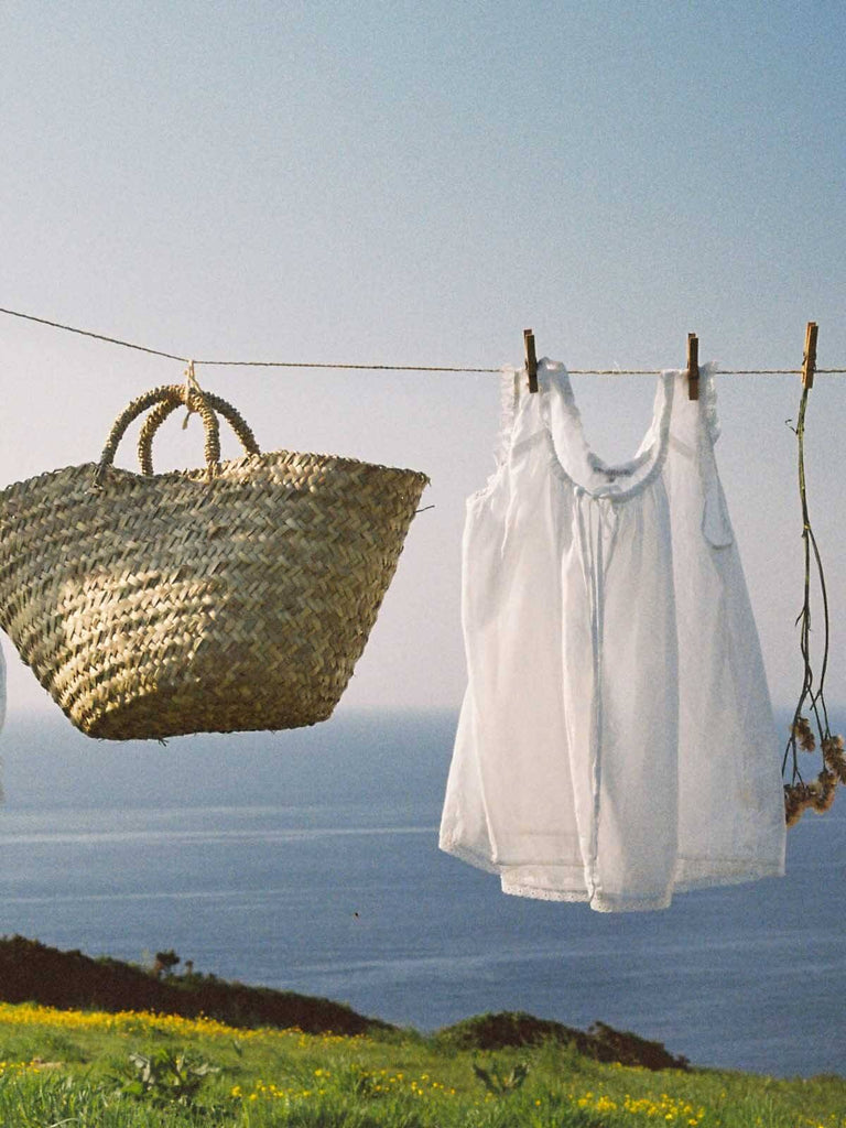 Small beldi basket being hung on a washing line alongside white linen and dried flowers