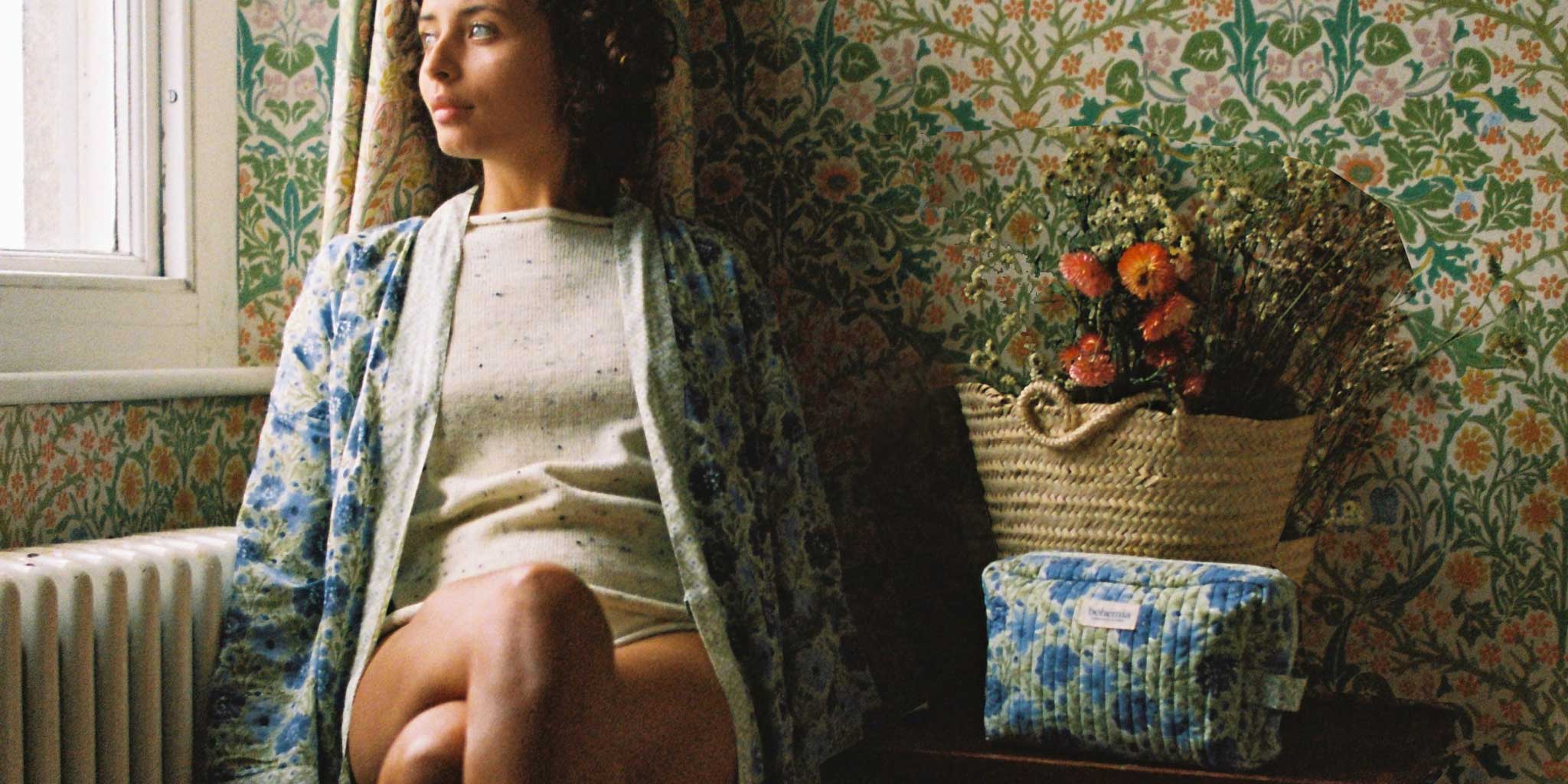 Model at a window wearing a Bohemia block print cotton robe in sage in a country house