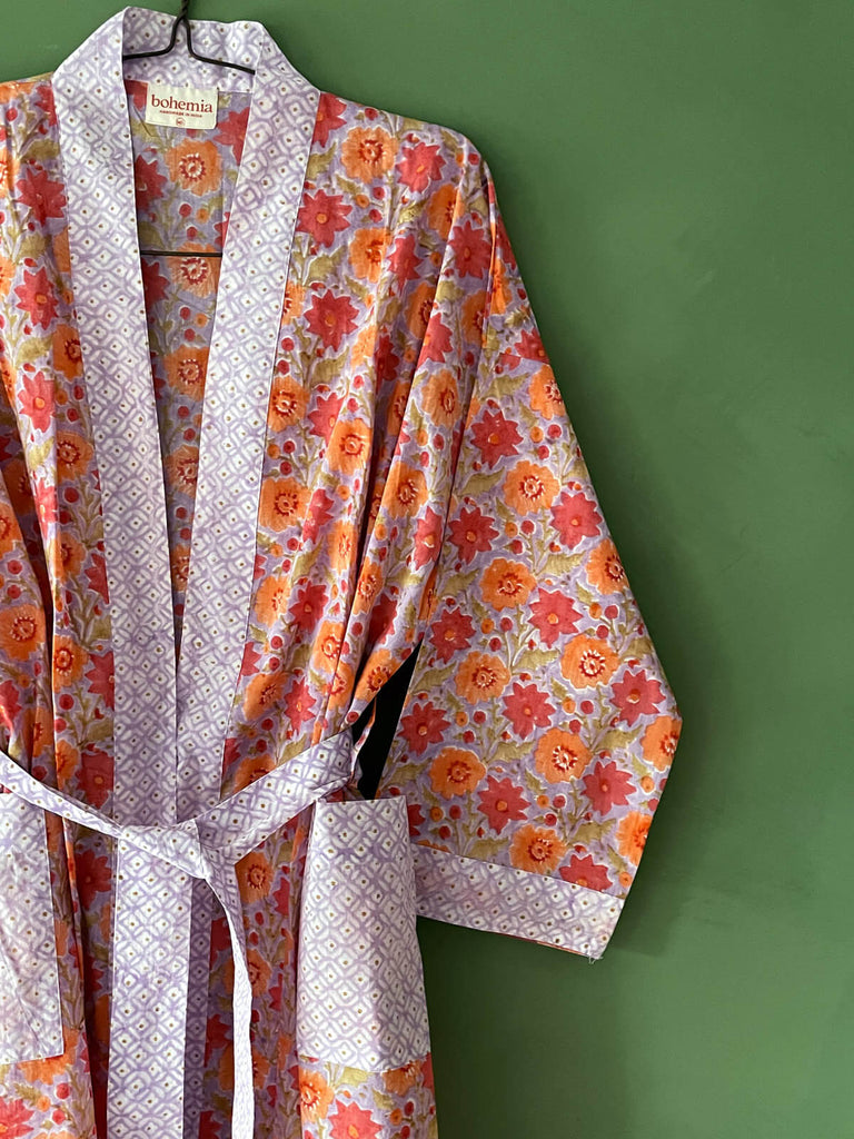 Close-up of a block print cotton robe in vibrant lilac with contrasting ditsy floral prints on the cuffs, pockets, trim, and belt | Bohemia