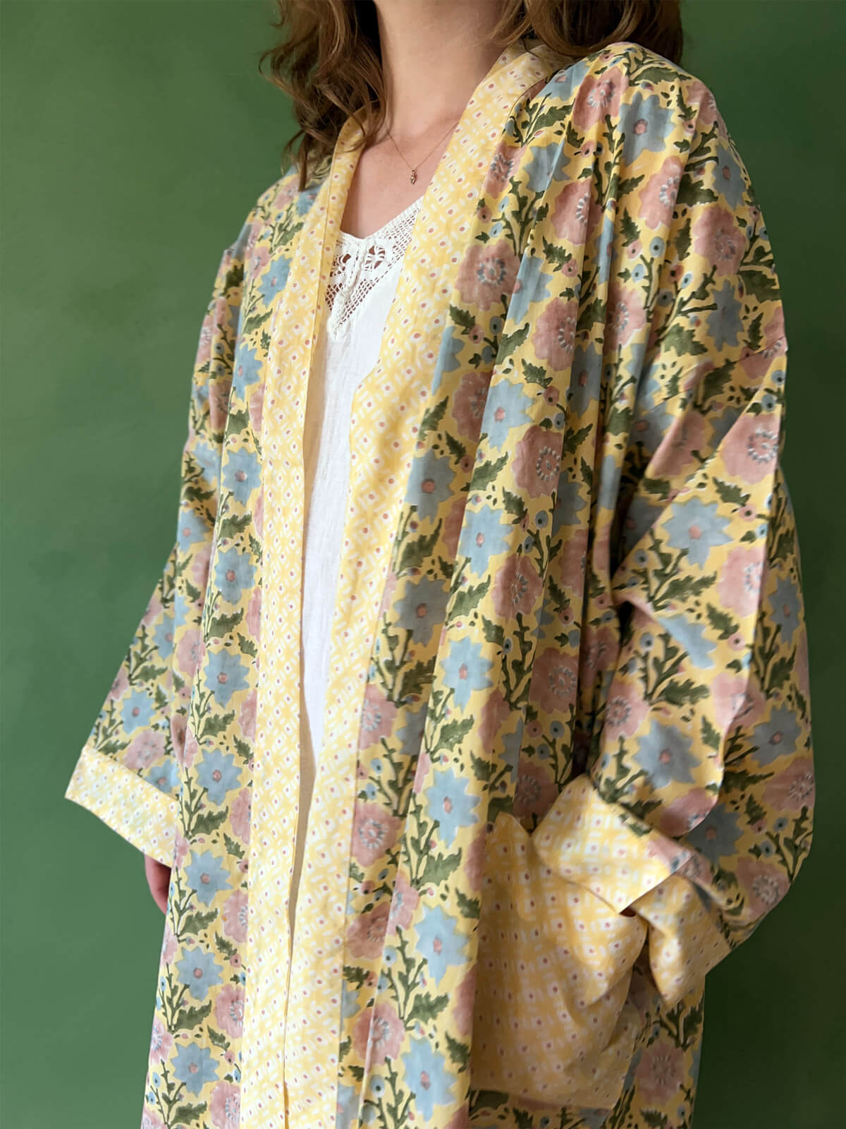 A close-up of a model wearing Bohemia floral block print cotton robe with contrasting pockets and trim.