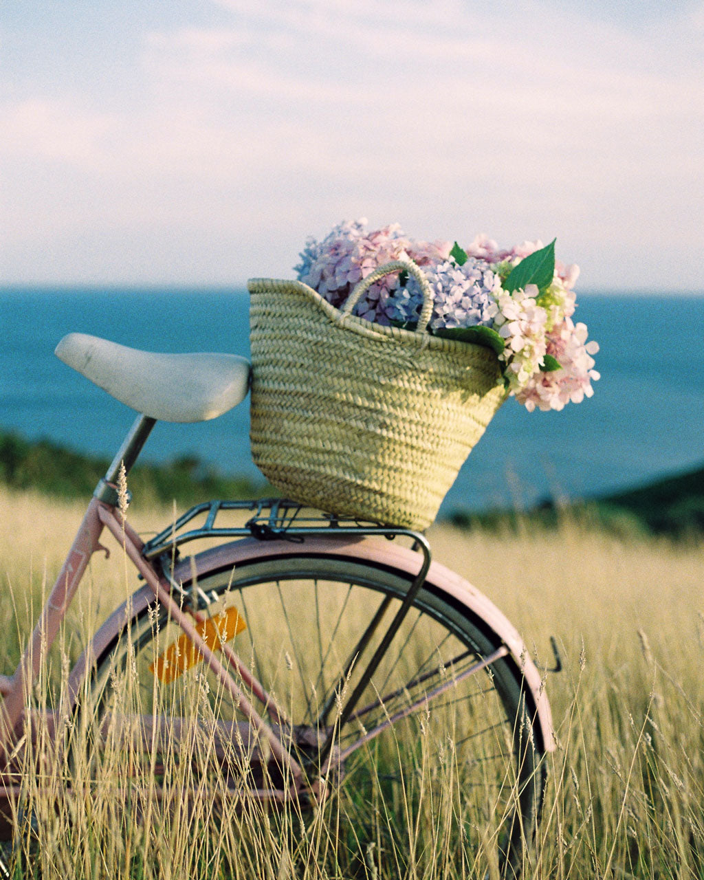 Bohemia Market Basket bag filled with flowers on a bike by the sea 