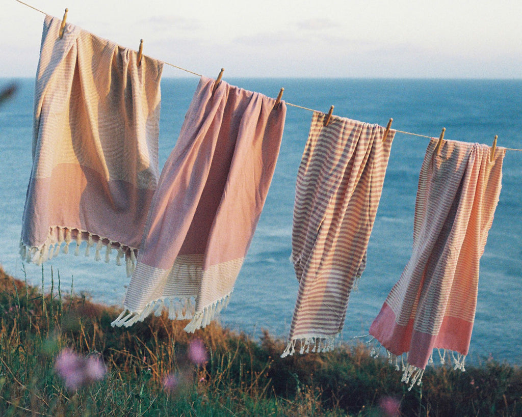 Pink striped Turkish hammam towels hanging by the beach
