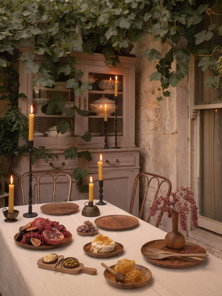 A festive tablescape with lit candles in iron candle holders