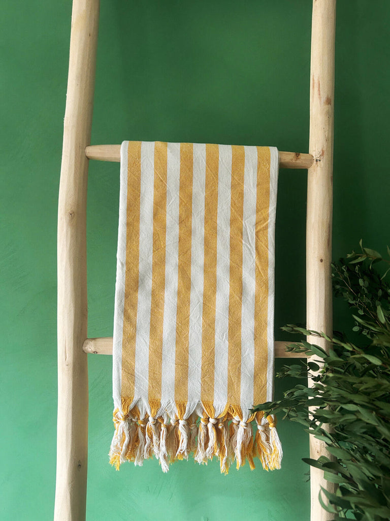Wide stripe mustard yellow authentic cotton hammam towel hanging on a wooden ladder