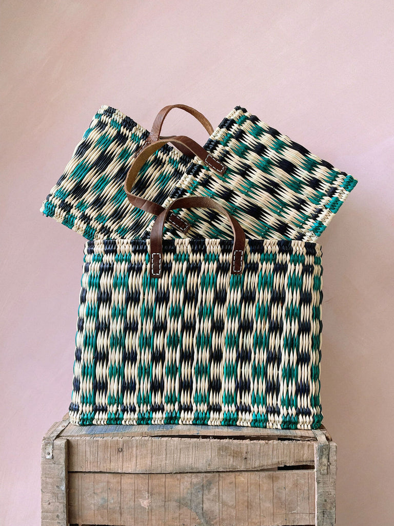 A stack of three different sizes of Chequered Reed Baskets in indigo and green
