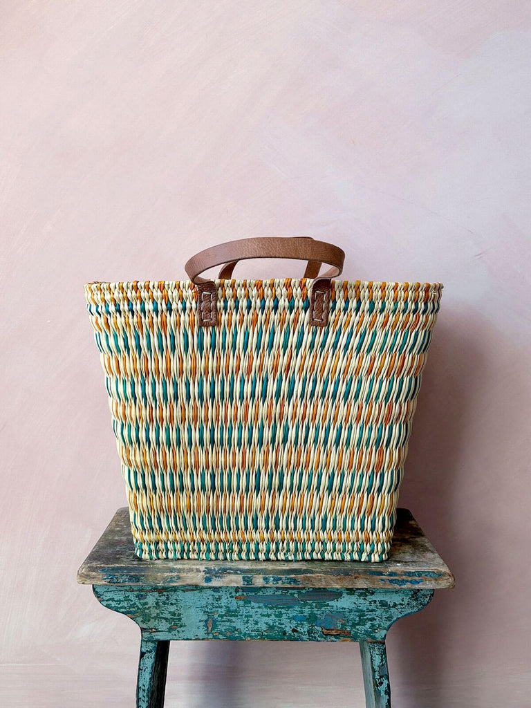 Colourful wholesale wicker reed shopper basket bag hand woven with orange and teal pattern with leather handles