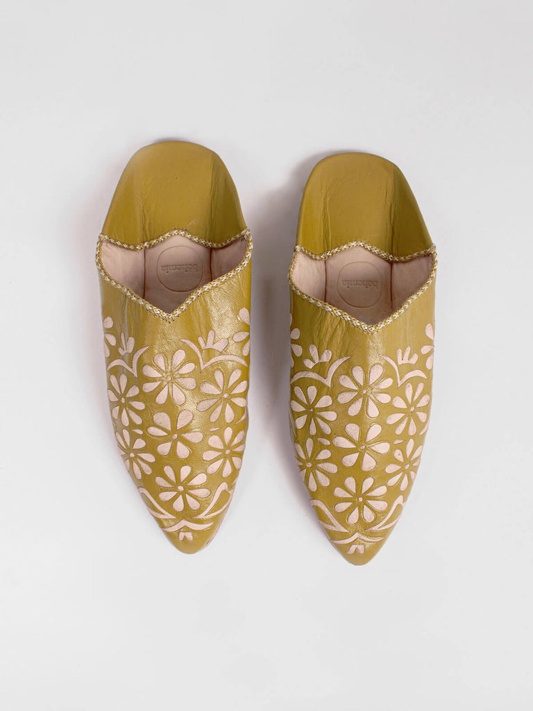 A pair of mustard leather decorative babouche slippers with a delicate cut work daisy pattern 