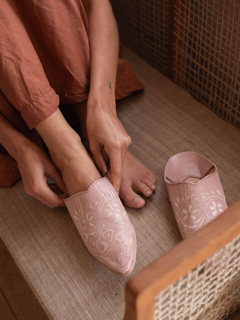 Model trying a pair of decorative babouche slippers in vintage pink