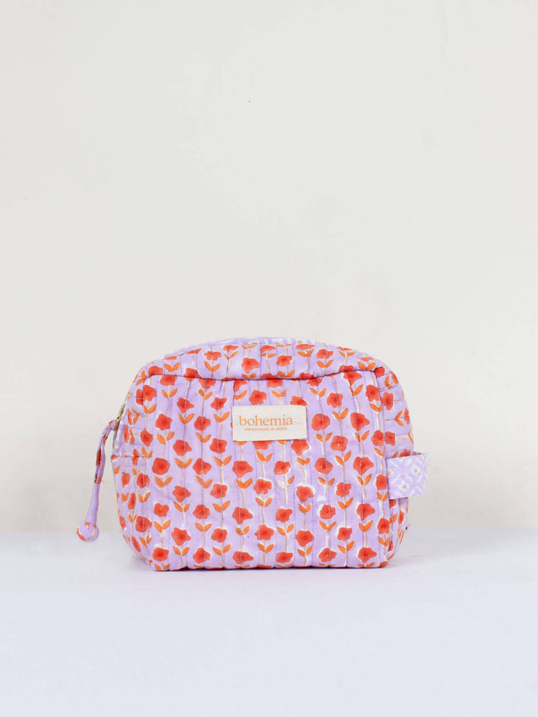 A quilted Garland washbag with lilac and orange ditsy floral block print pattern