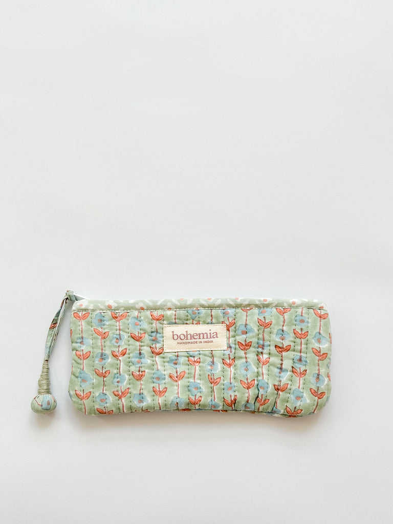 A long quilted pencil case by Bohemia, featuring a soft green-blue and terracotta ditsy floral pattern and a handcrafted zip pull