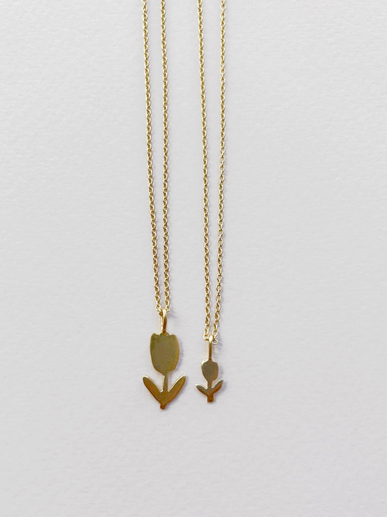 Small and tiny minimalist gold tulip necklaces side by side