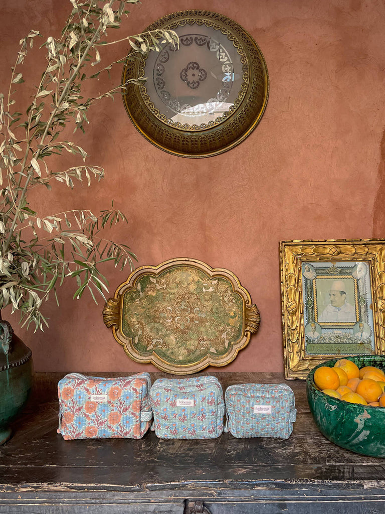 A set of hand block printed cotton washbags in blue-green, displayed against a terracotta wall with a Moroccan-style interior | BohemiaDesign