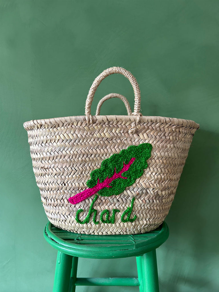 A close-up of a wholesale market basket bag with short handles, featuring a hand-embroidered illustration of chard and text | Bohemia Design