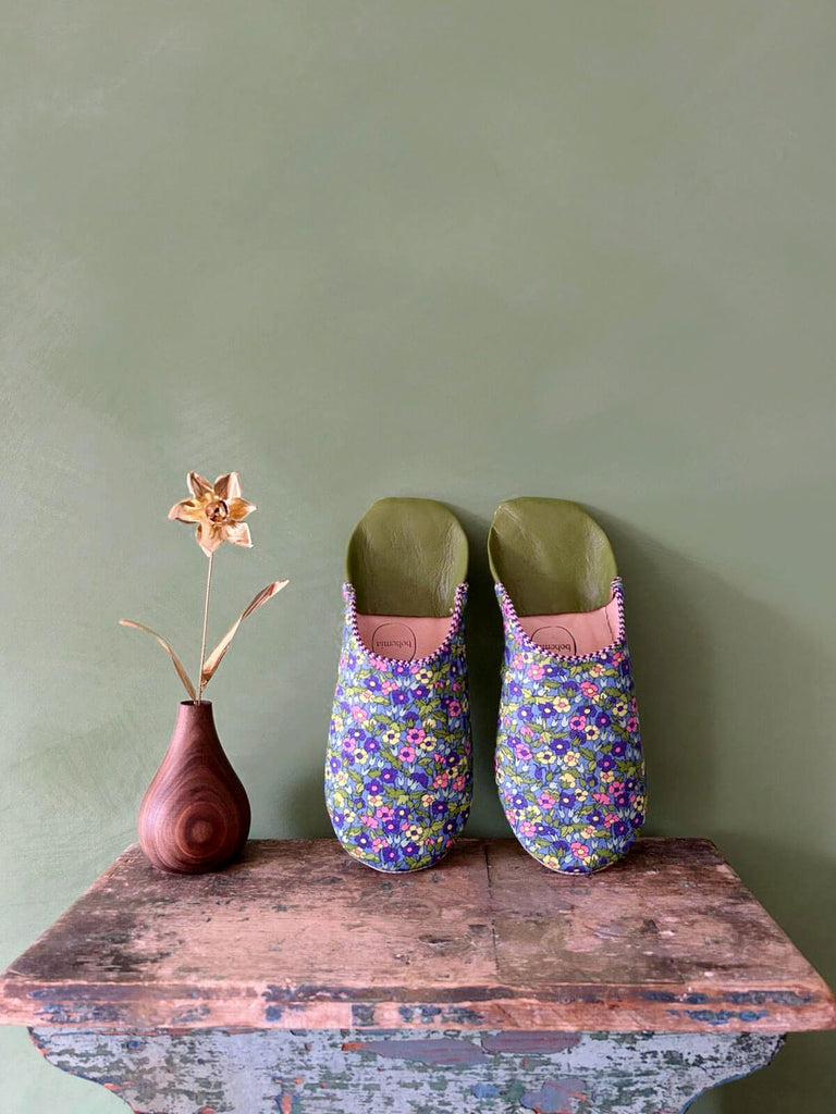 Liberty print Moroccan leather babouche slippers on a rustic stool