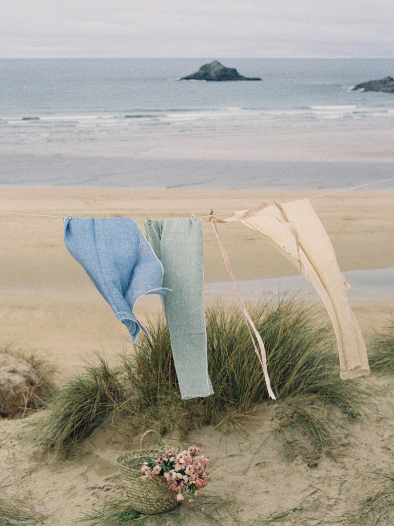 Linen Scarf in Indigo and Lemon hanging on a washing line by the sea