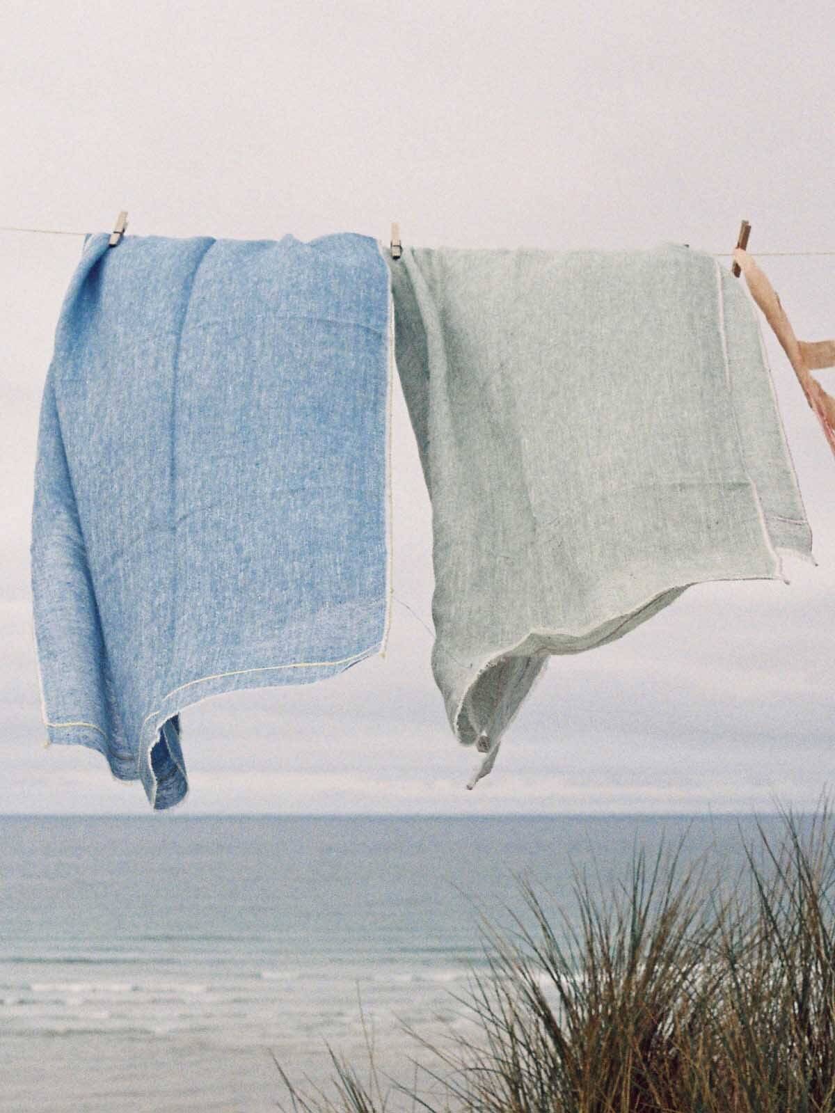 Linen Scarf in Indigo and Lemon hanging on a washing line by the sea