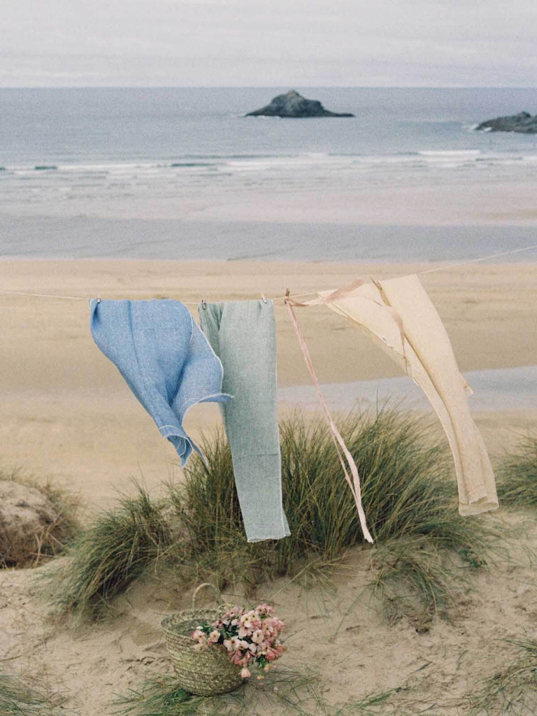 Linen Scarf in Sage and Lilac hanging on a washing line by the sea