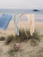 Linen Scarf in Sage and Lilac hanging on a washing line by the sea