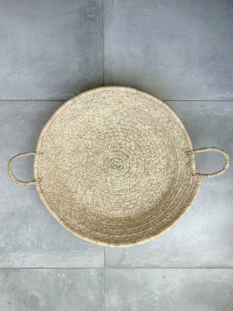 A large woven plate or platter handwoven from natural palm leaf fibres