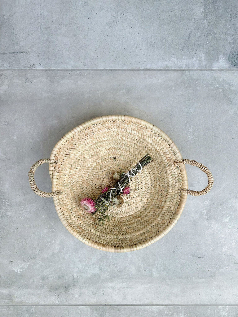 A natural Moroccan woven plate with dried flowers