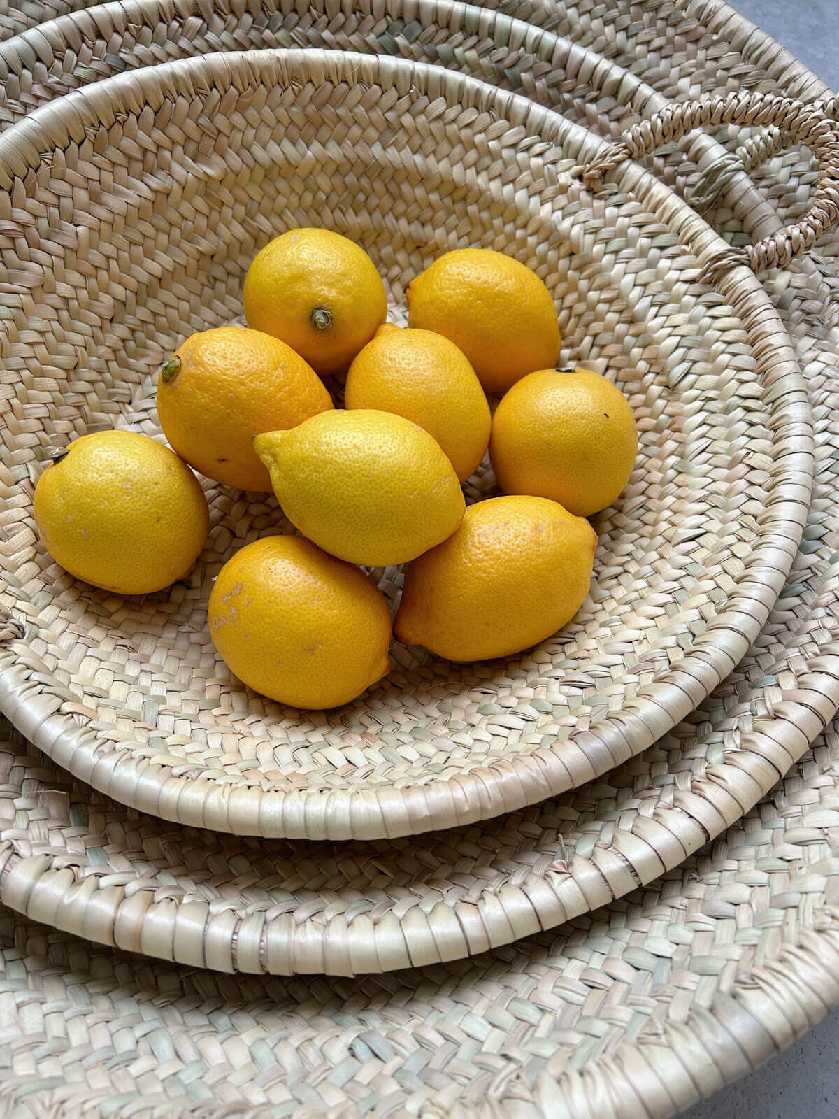 Set of three Moroccan woven plates holding lemons