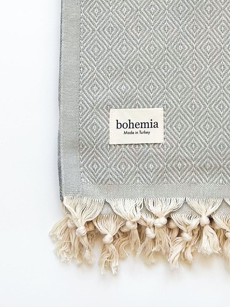 Nordic Dot Hammam Towel in pearl grey diamond pattern, fringe detail, and a Bohemia label.