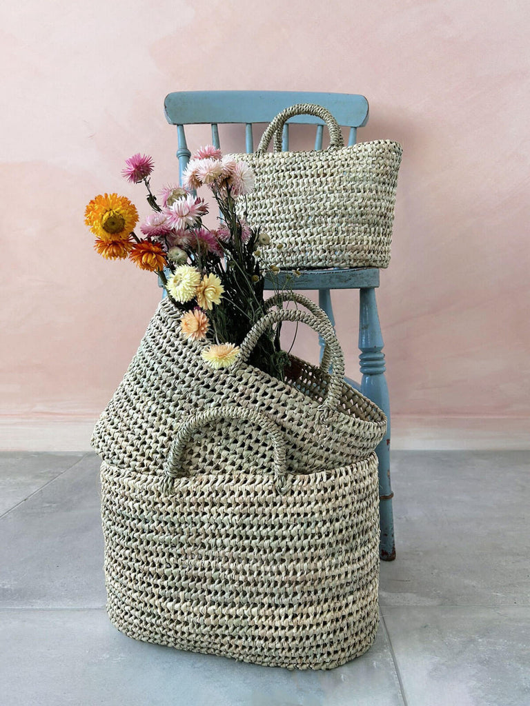Wholesale oval shaped nesting baskets handcrafted from natural woven palm leaf by Moroccan artisans