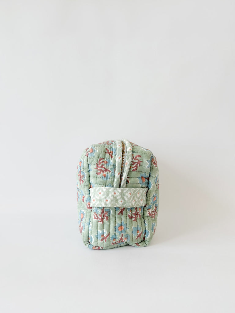 Side view showing zip and handle of a Posie cotton quilted washbag with green, blue and terracotta floral block print by Bohemia