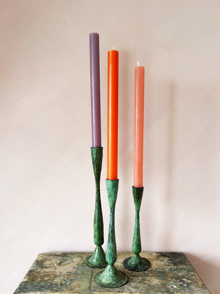 A set of three Shelley candle holders with a beautiful verdigris patina finish paired with colourful candlesticks