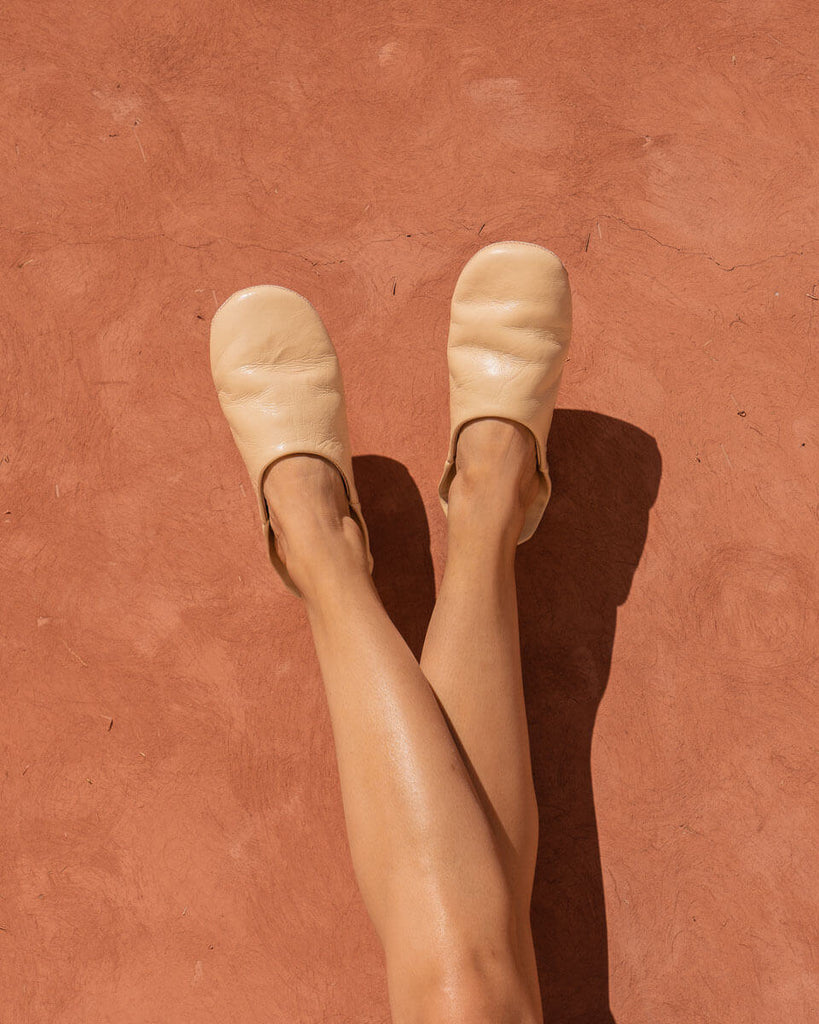 Bohemia Summer babouche slippers being worn in front of a sunny terracotta wall