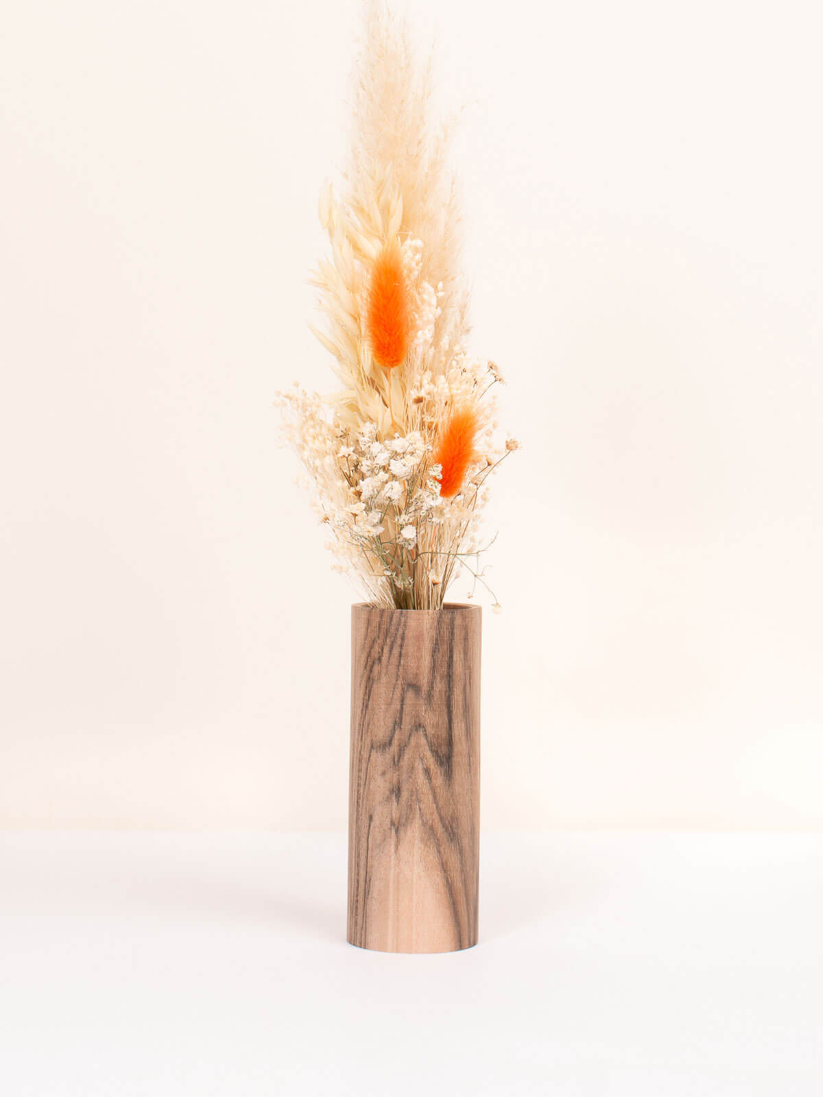 Medium walnut wood vase with a posy of orange dried flowers