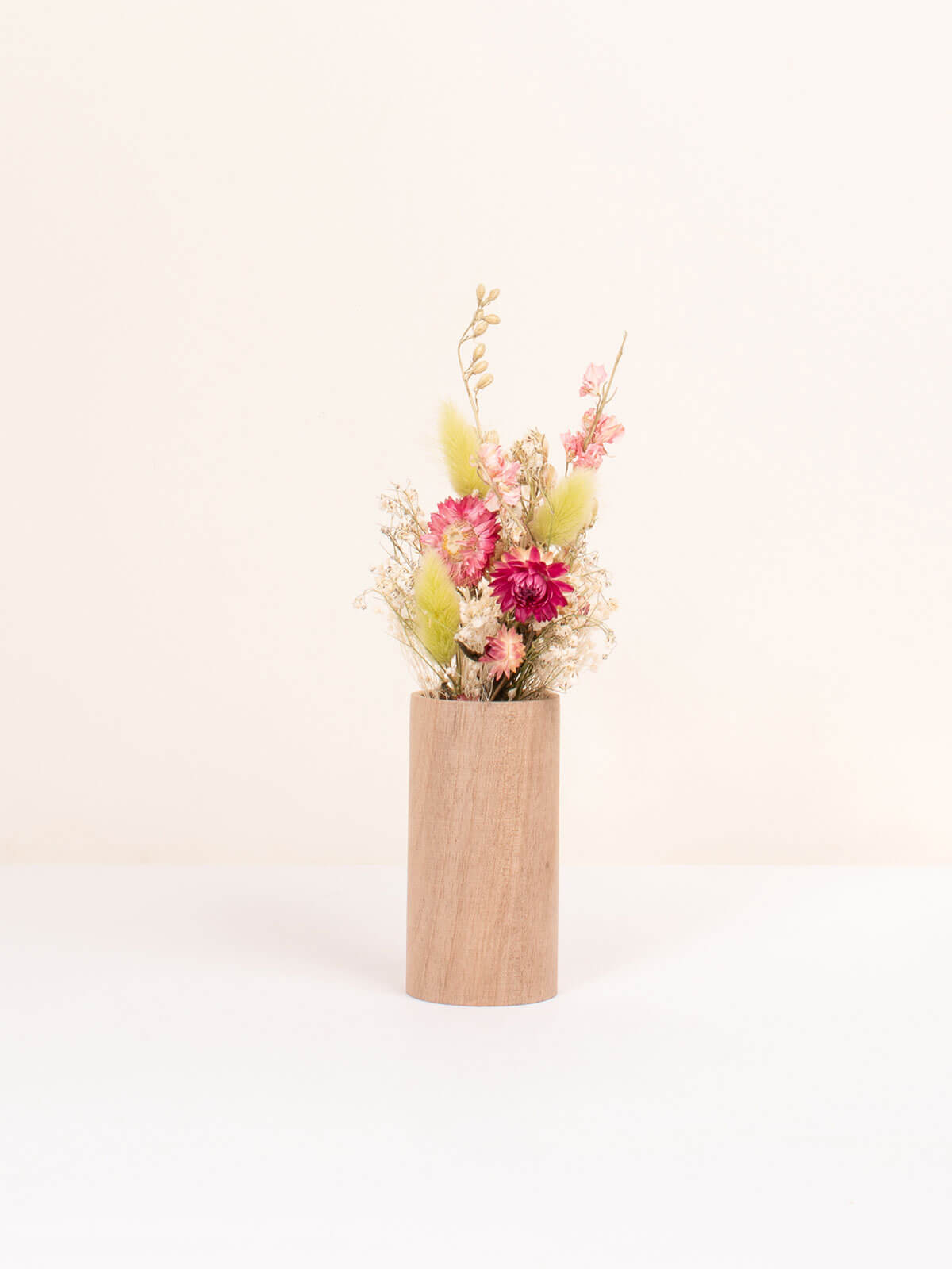 Small walnut wood vase with a posy of colourful dried flowers