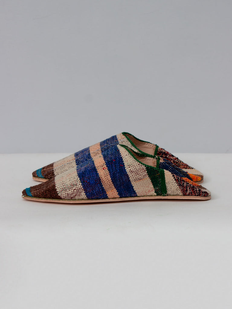 Side view of the Moroccan pointed slippers handmade from natural leather and vintage striped boujad fabric.