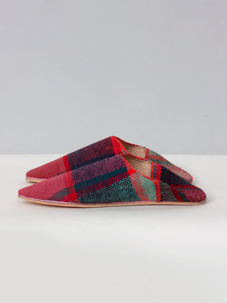 Side view of limited edition Moroccan boujad pointed leather and textile babouche slippers with a red and pink check pattern.