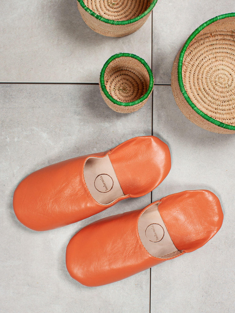 Handmade Moroccan Babouche Basic Slippers in Tangerine Coloured Leather by Bohemia Design with raffia baskets
