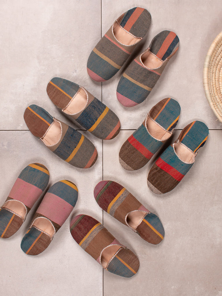 Group of Bohemia design Moroccan babouche boujad slippers in camel stripe pattern on grey tiles