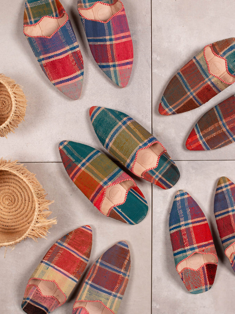 Group of Bohemia design Moroccan babouche boujad slippers in Fez check pattern on grey tiles with raffia baskets