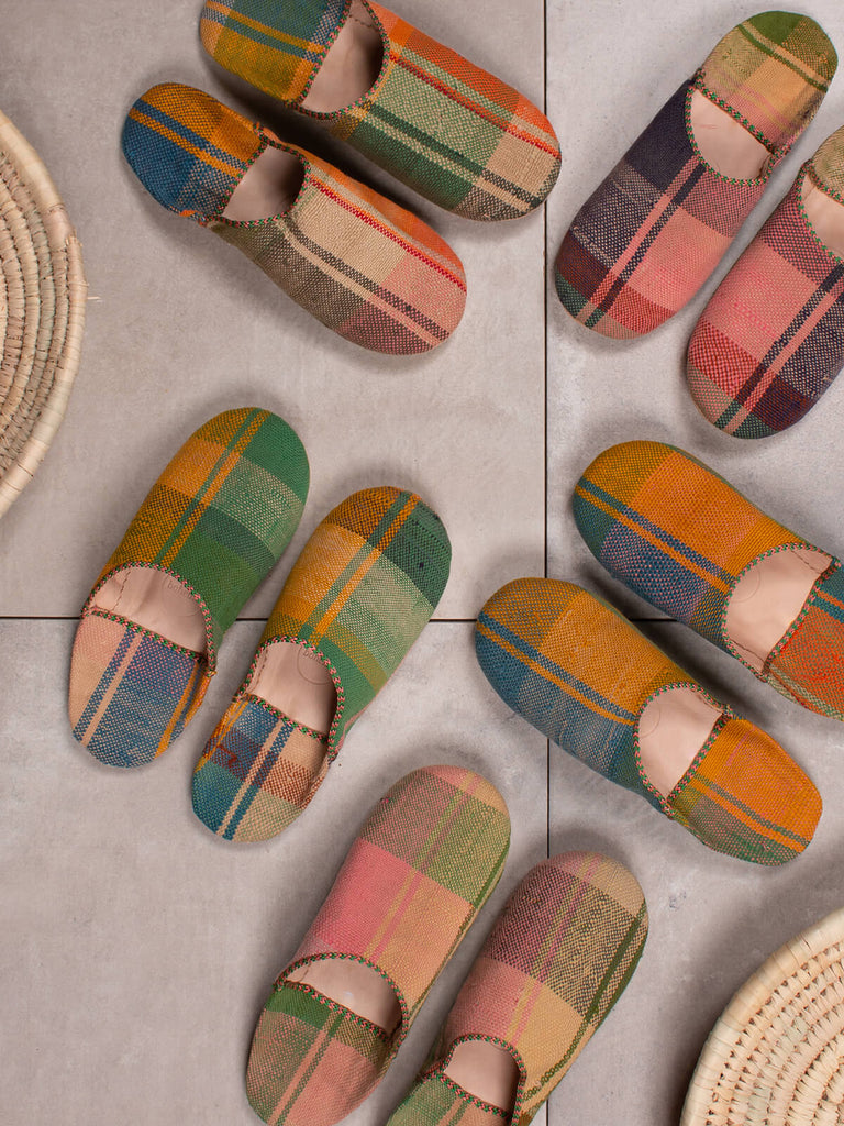 Group of Bohemia design Moroccan babouche boujad slippers in spring check on grey tiles with raffia baskets
