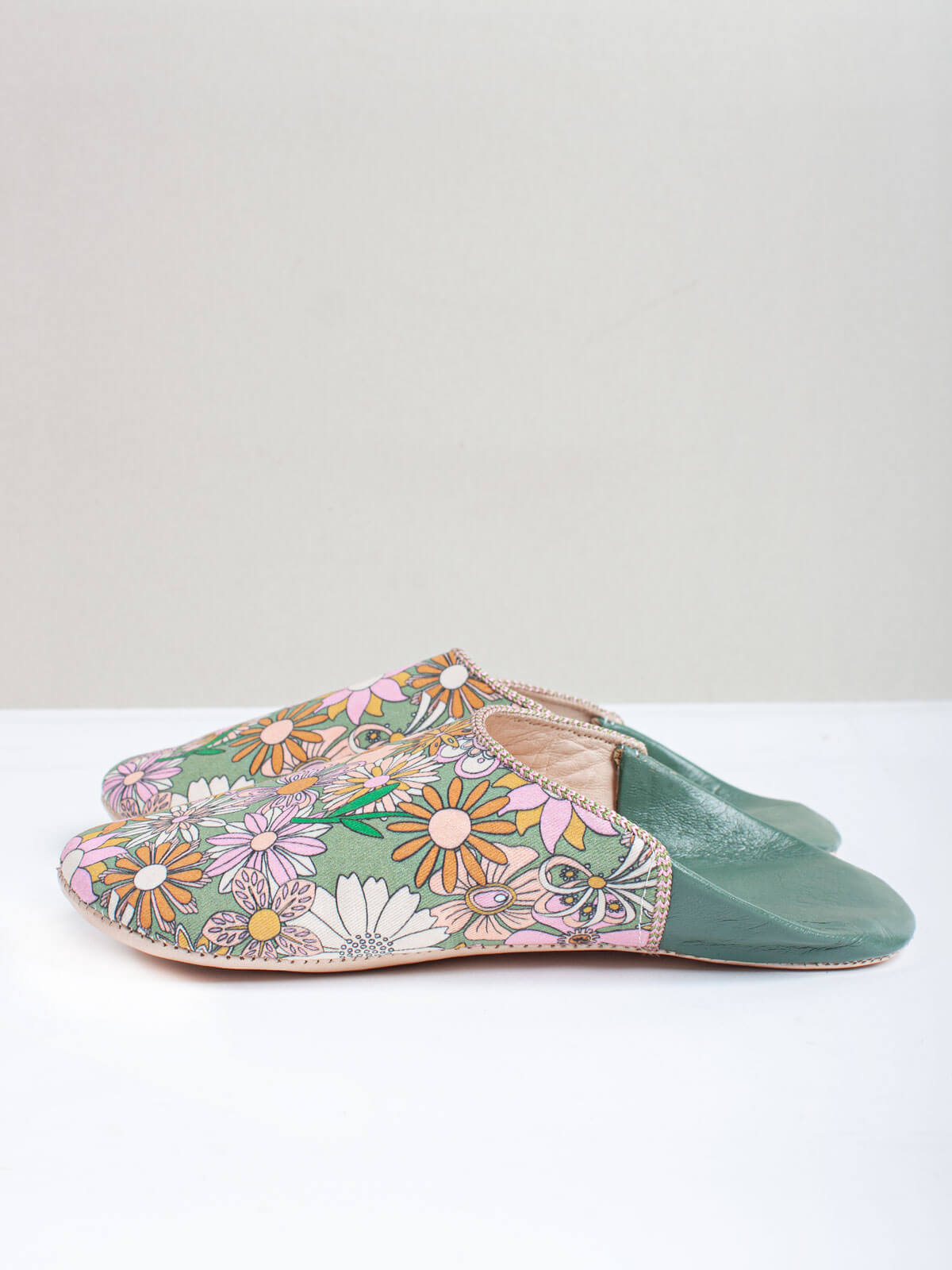 A pair of Moroccan babouche slippers in an olive and pink floral pattern by Bohemia Design